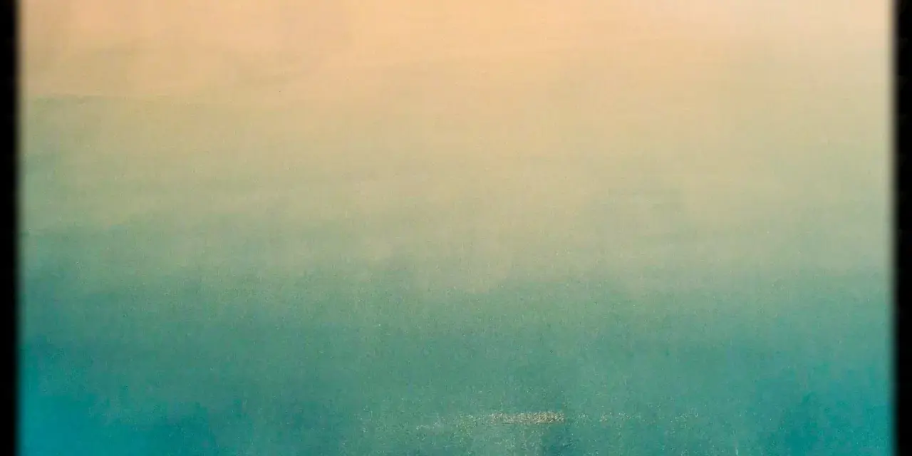 Un dégradé peinture facile, du beige clair au bleu-vert profond, évoquant un ciel au-dessus de l'océan.