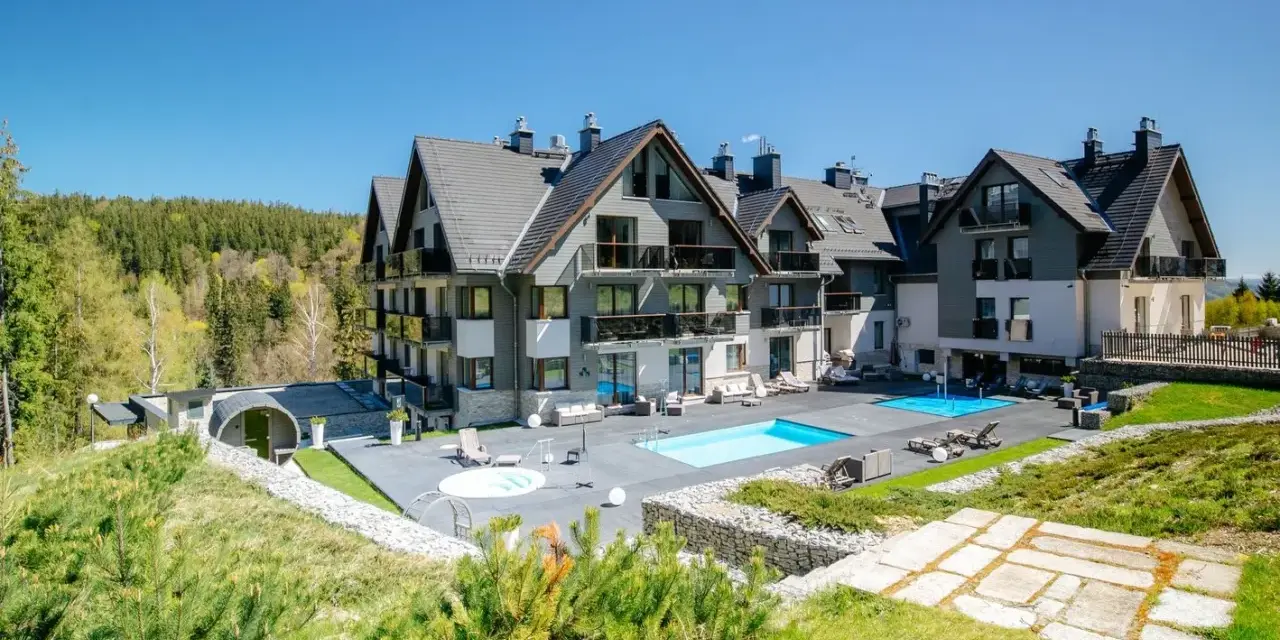 Nowoczesny hotel w Szklarskiej Porębie z basenem i jacuzzi, otoczony zielenią i lasem. Idealne miejsce na wypoczynek.