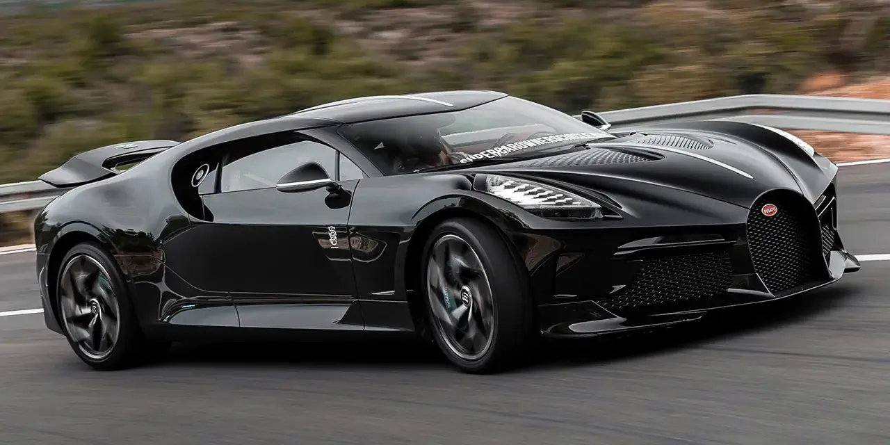Czarny Bugatti La Voiture Noire pędzi po krętej drodze. Zastanawiasz się, ile kosztuje ten cud motoryzacji?