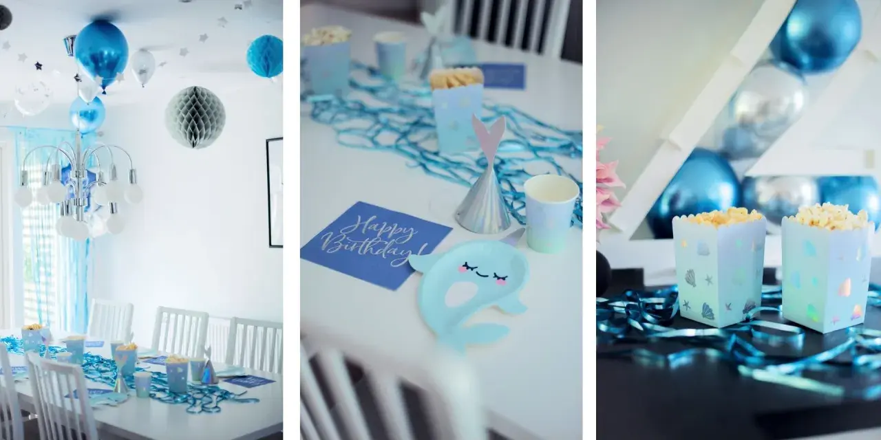 Blå och silverfärgade ballonger, stjärnor och honkoms dekorationer skapar en festlig stämning. Bordet är dukat med havstema, inklusive popcornaskar och en "Happy Birthday"-servett.