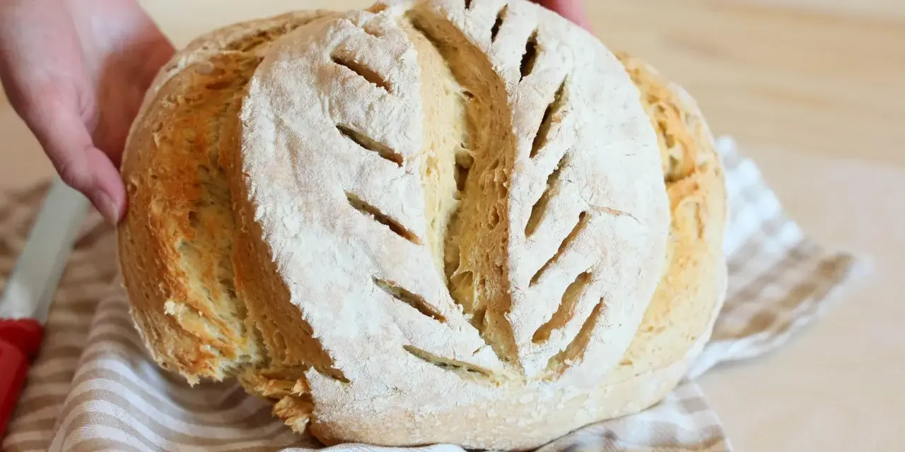 Pane fatto in casa, fragrante e dorato, con tagli che ricordano la ricetta della nonna.