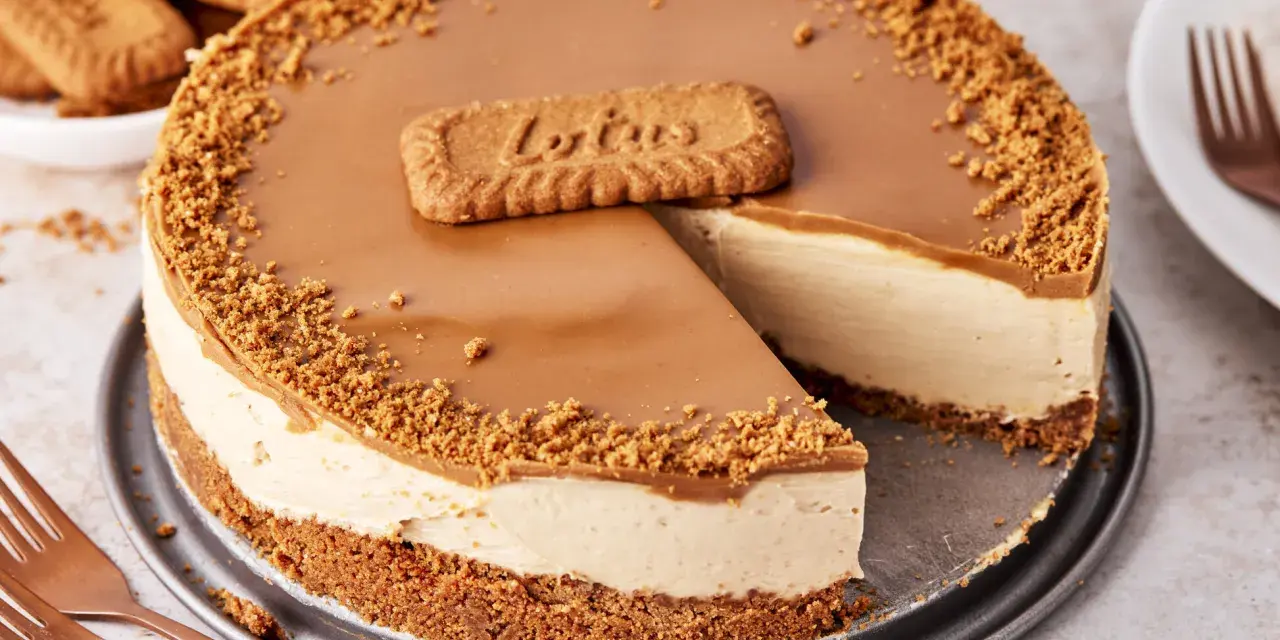 Ein cremiger Lotus Cheesecake mit Karamellglasur und Keksbröseln, dekoriert mit einem Lotus-Keks.