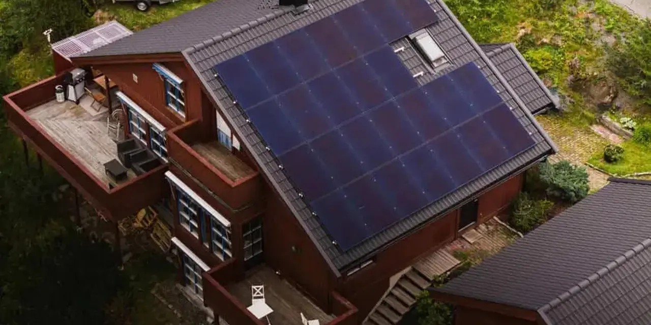 Dom z panelami fotowoltaicznymi na dachu. To rozwiązanie, co to fotowoltaika, pozwala na produkcję własnej energii elektrycznej ze słońca.