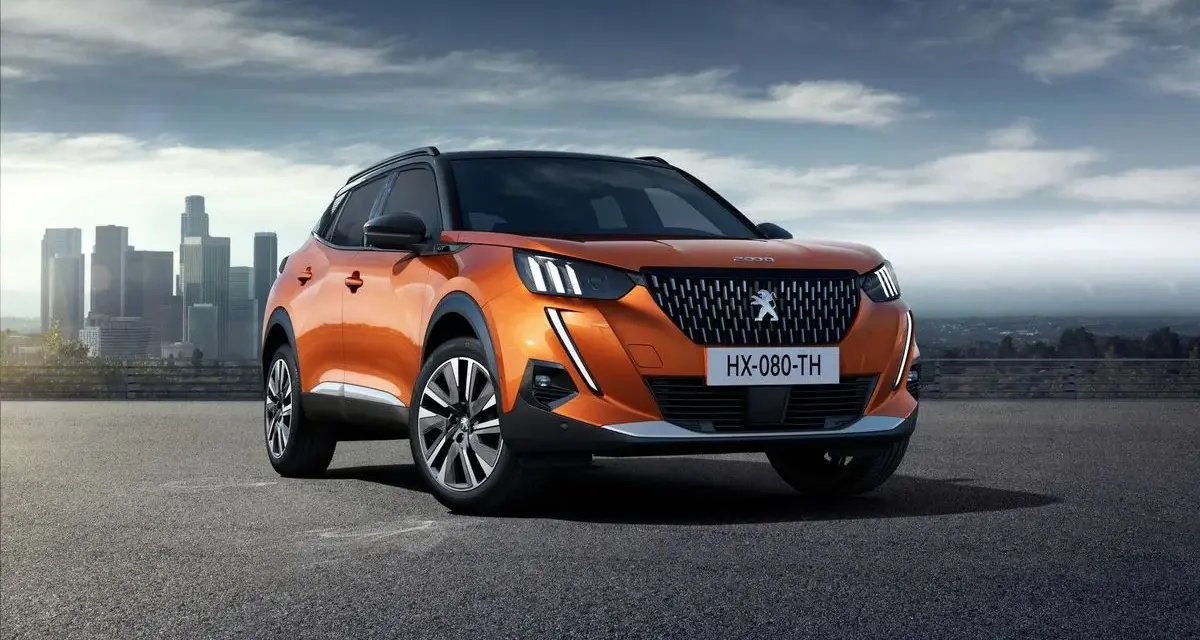 Pomarańczowy Peugeot 2008 na tle miasta. Sprawdź jego wymiary i możliwości.
