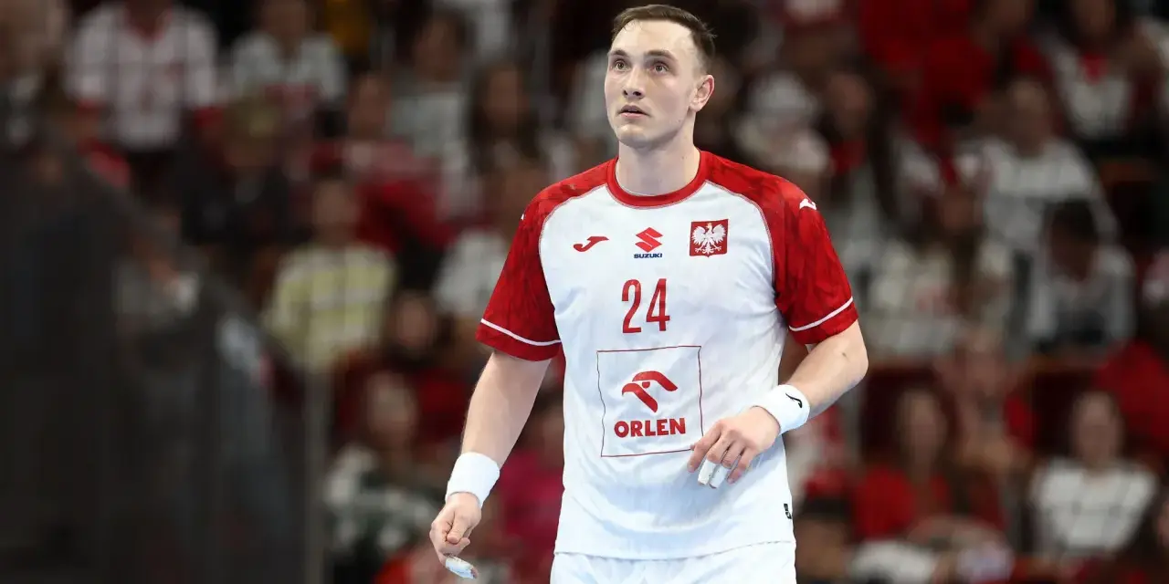 Wiktor Jankowski, numer 24, w białej koszulce z czerwonymi rękawami, z orłem na piersi, na tle trybun.