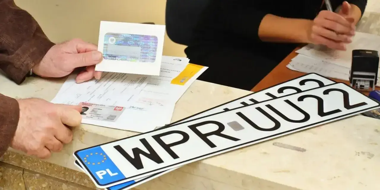 Nowe rejestracje samochodowe w urzędzie. Klient pokazuje dokumenty, a na ladzie leżą tablice rejestracyjne.