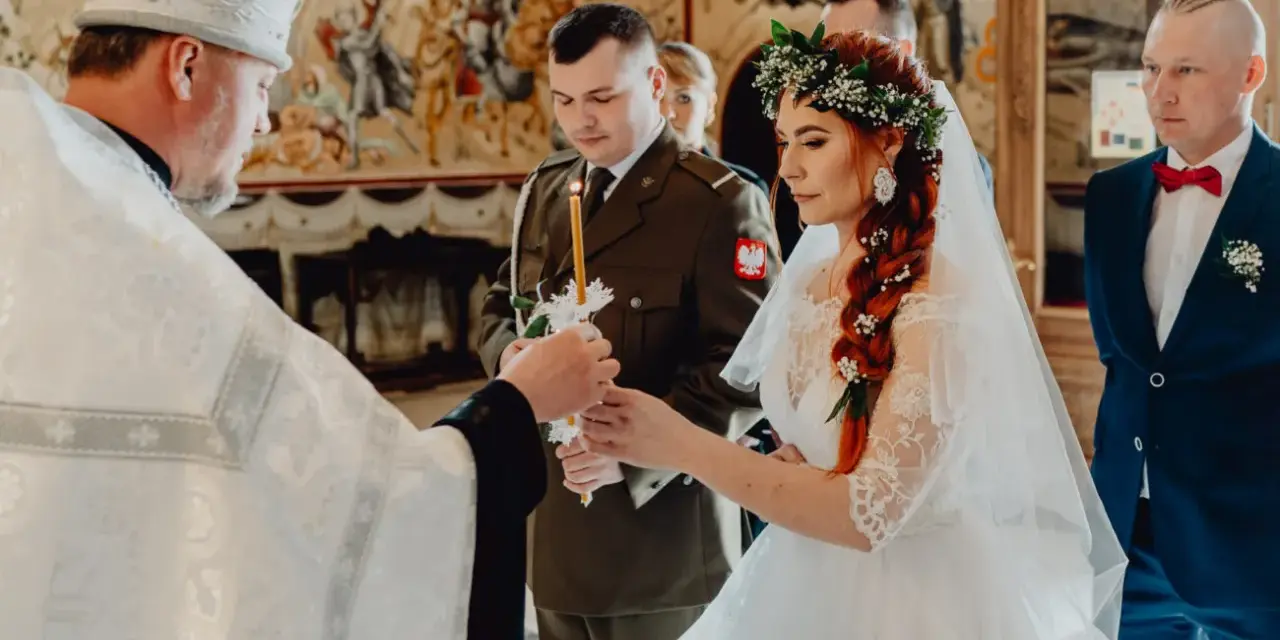 Piękny ślub prawosławny. Panna młoda w wianku, pan młody w mundurze wojskowym. Ceremonia z udziałem duchownego.