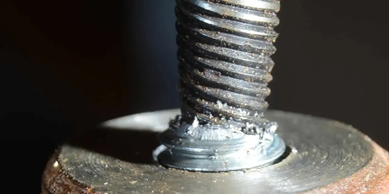 Uszkodzona śruba w aluminiowej obudowie. Widoczne ślady po próbie wykręcenia urwanej śruby z aluminium.