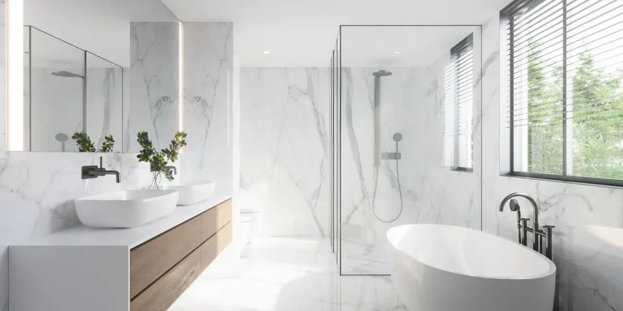 Salle de bain moderne avec baignoire îlot, double vasque et douche vitrée. La faïence marbrée blanche illumine l'espace, créant une ambiance épurée et luxueuse.
