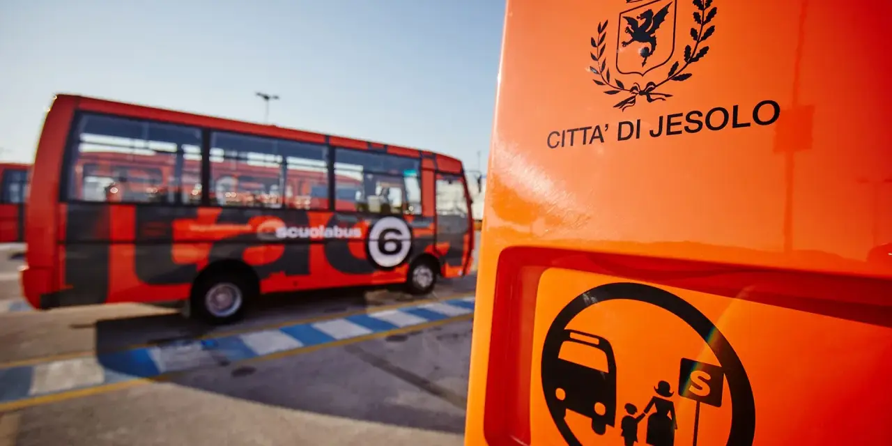Autostazione Jesolo: scuolabus rosso con stemma "Città di Jesolo" e simbolo di fermata.