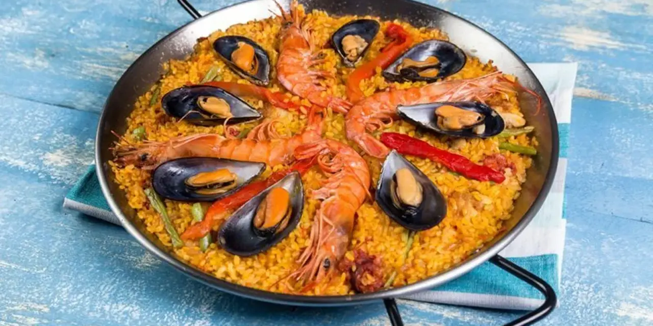 Paella mixta con gambas y mejillones, un festín de sabores mediterráneos en una paellera.