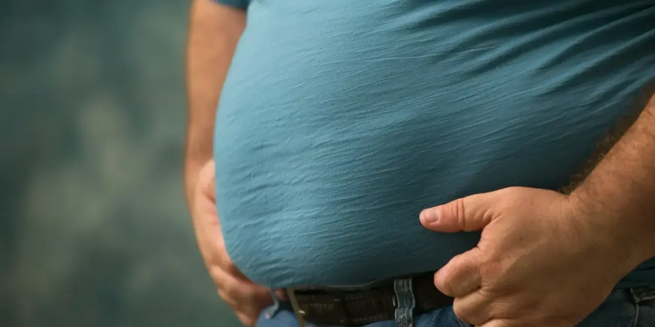 Mężczyzna z widocznym brzuchem, który może być oznaką zespołu metabolicznego.