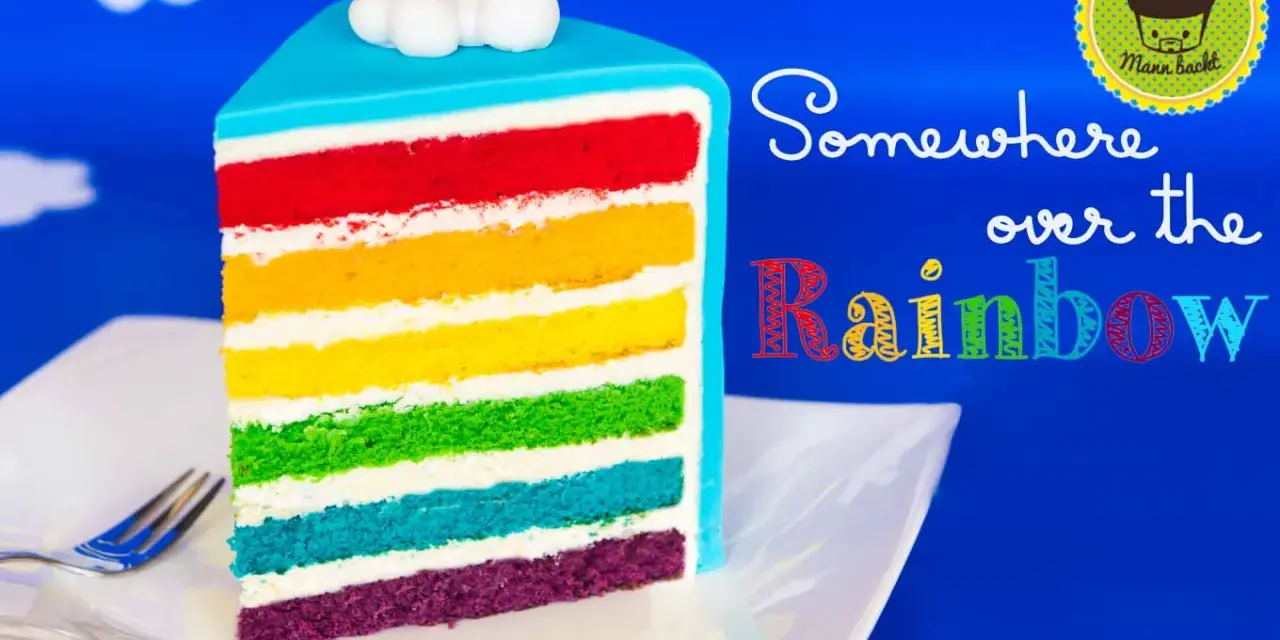 Ein Stück regenbogen kuchen mit bunten Schichten und Wolken-Deko.