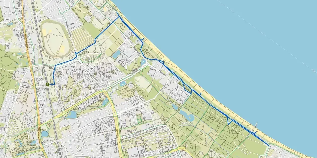 Mapa z zaznaczoną trasą rowerową wzdłuż wybrzeża. Nadmorska trasa rowerowa Trójmiasto prowadzi przez tereny zielone i miejskie.