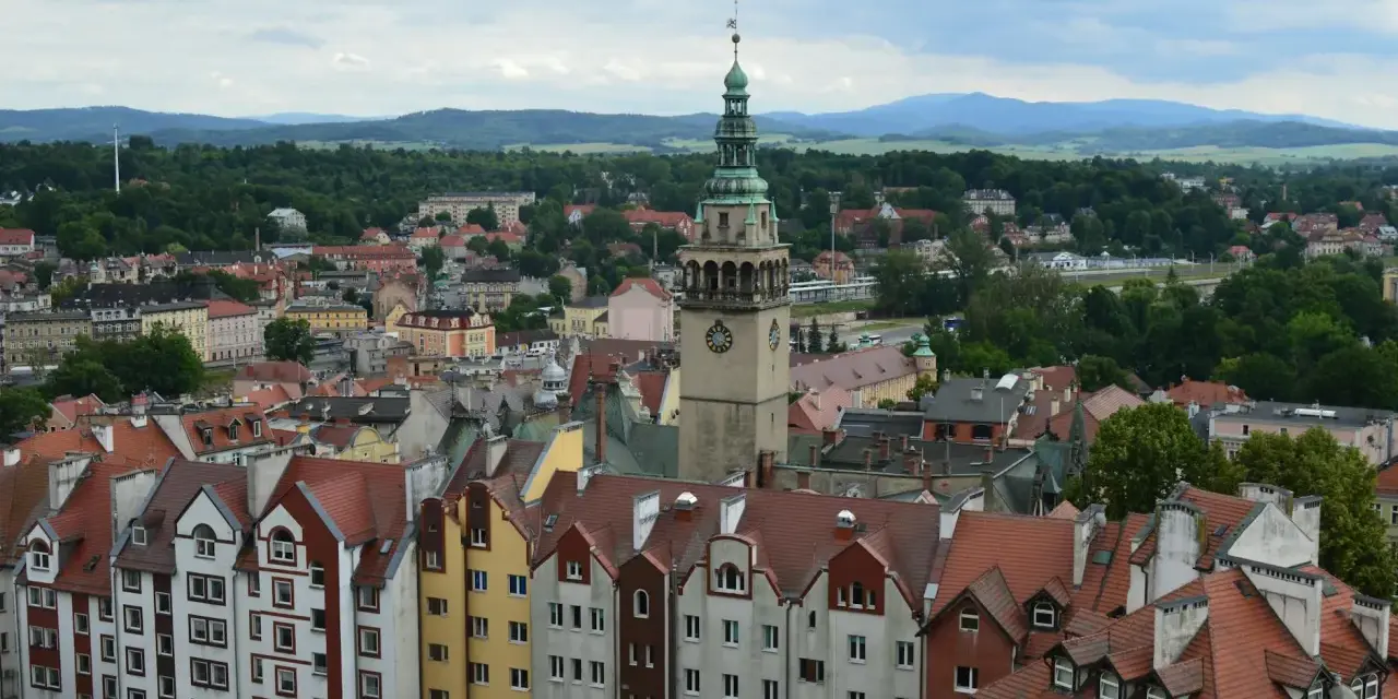 Widok na kłodzko stare miasto z charakterystyczną wieżą zegarową i kolorowymi kamienicami.
