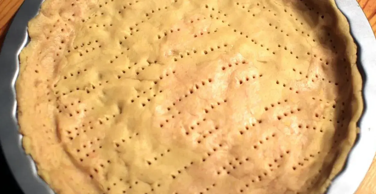 Surowy spód do tarty, z widocznymi dziurkami, czeka na nadzienie. Tarta na kruchym spodzie czy na cieście francuskim?