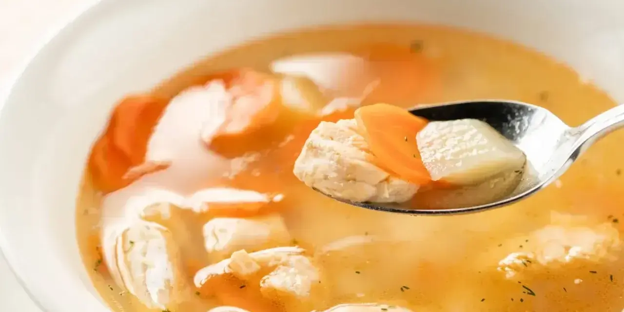 Łyżka z kawałkami ryby, marchewki i ziemniaków w aromatycznym bulionie. To smak dzieciństwa, jak zupa rybna przepis babci.