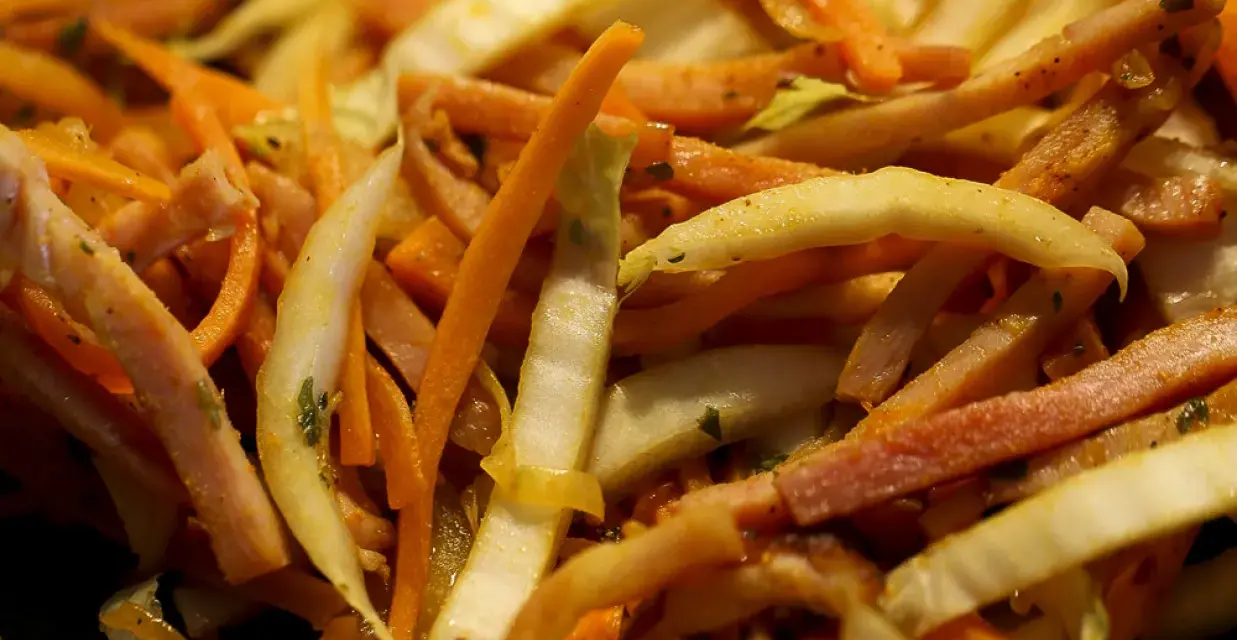 Pokrojone w słupki marchewka, fasolka i inne warzywa w daniu stir-fry.