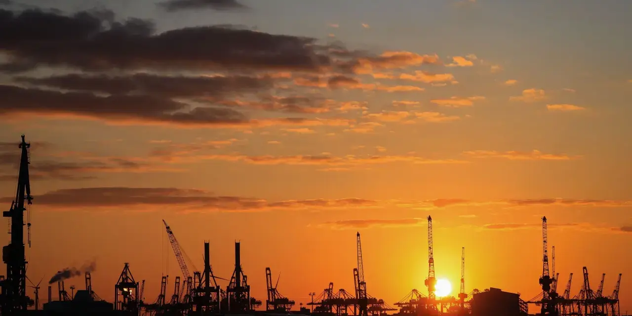 Silhouetten von Kränen im Hamburger Hafen bei Sonnenuntergang. Perfekt für die Pfingstferien in Hamburg.