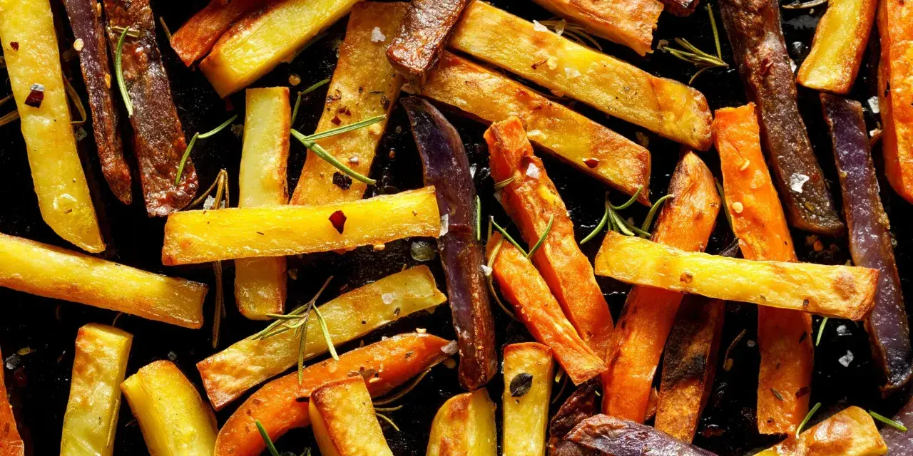 Pieczone frytki z ziemniaków i marchewki z rozmarynem i przyprawami.