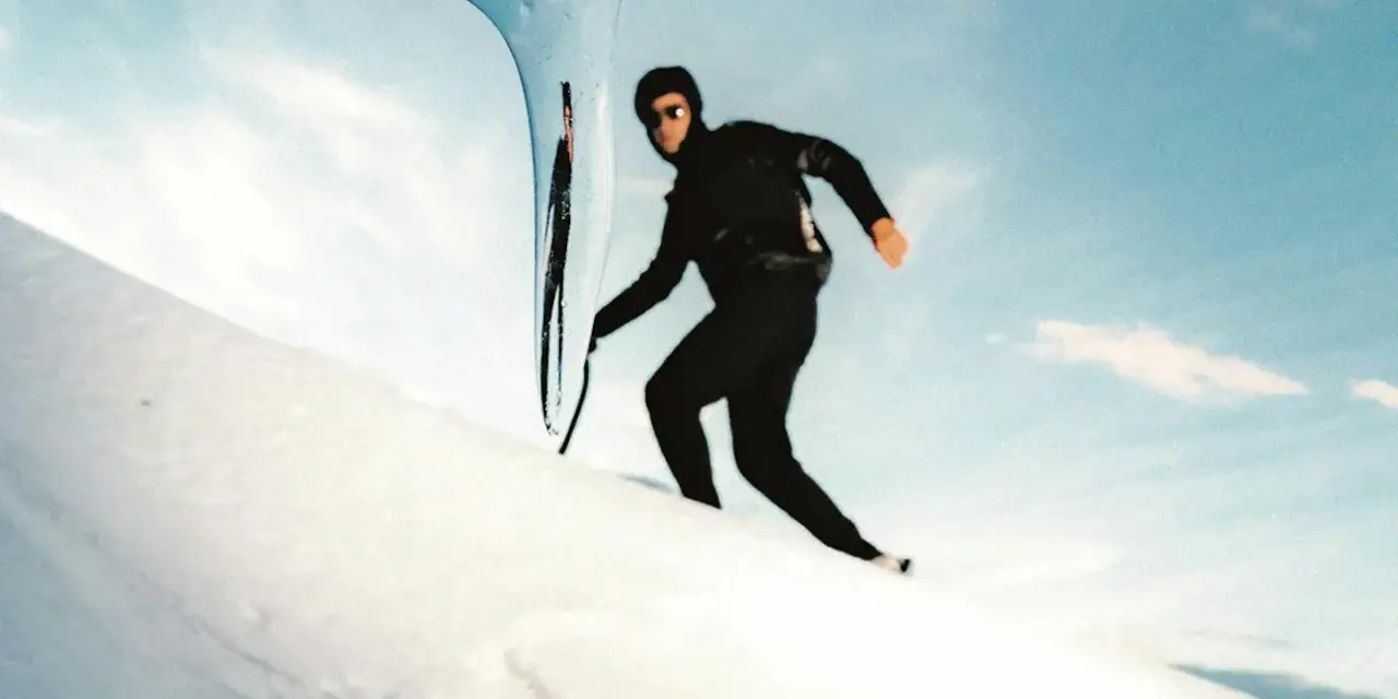 Kilian Jornet desciende el Mont Blanc con agilidad, su silueta negra contra la nieve y el cielo azul.