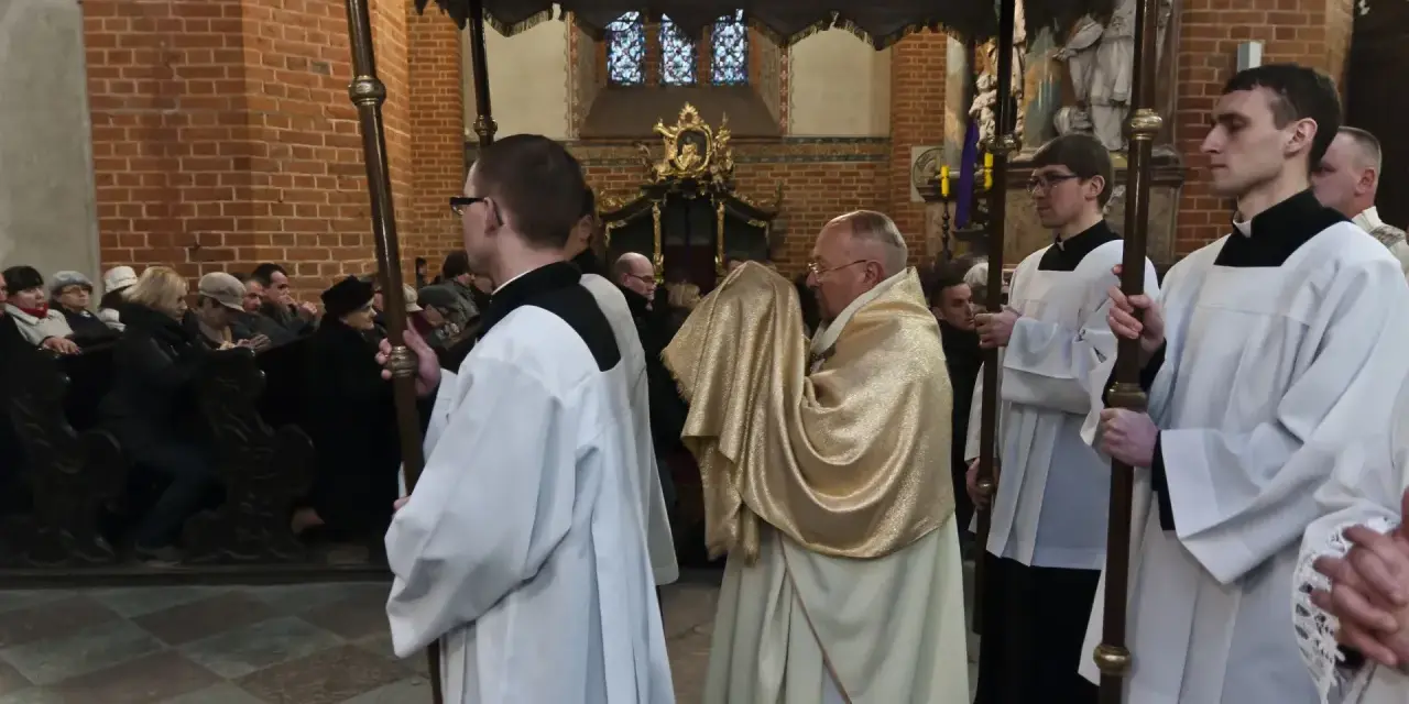 Uroczysta procesja w kościele, kapłan niesie monstrancję okrytą złotym welonem. To symboliczna rezurekcja.