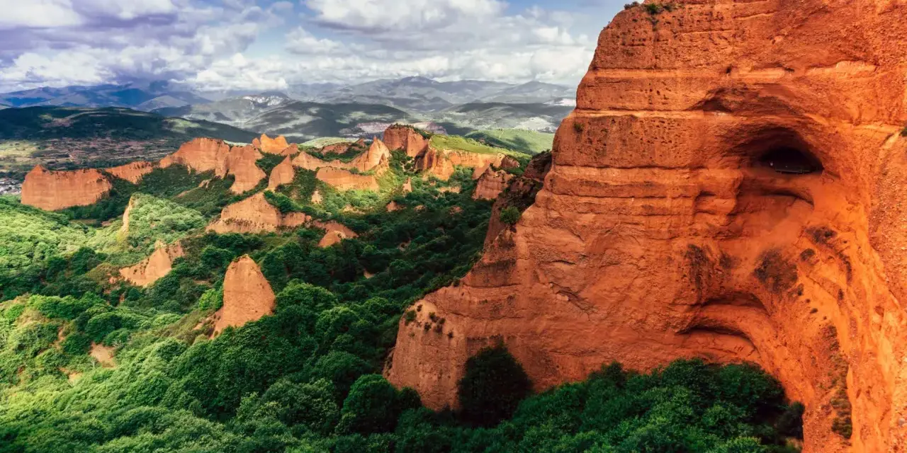 Paisaje dramático de Las Médulas, uno de los parques de España más impresionantes, con sus rocas rojizas y vegetación exuberante.