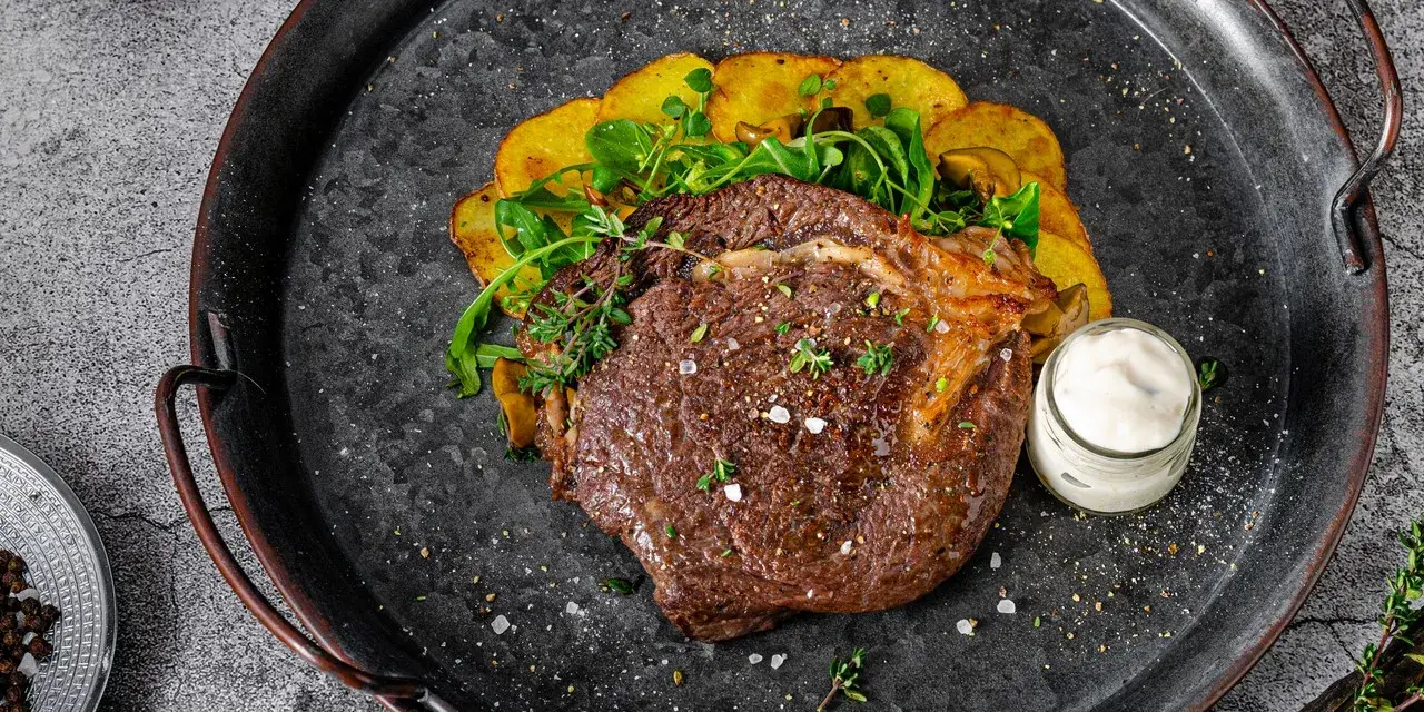 Un jugoso lomo bajo de vaca a la parrilla, acompañado de patatas crujientes y una salsa cremosa. ¡Un festín para los sentidos!