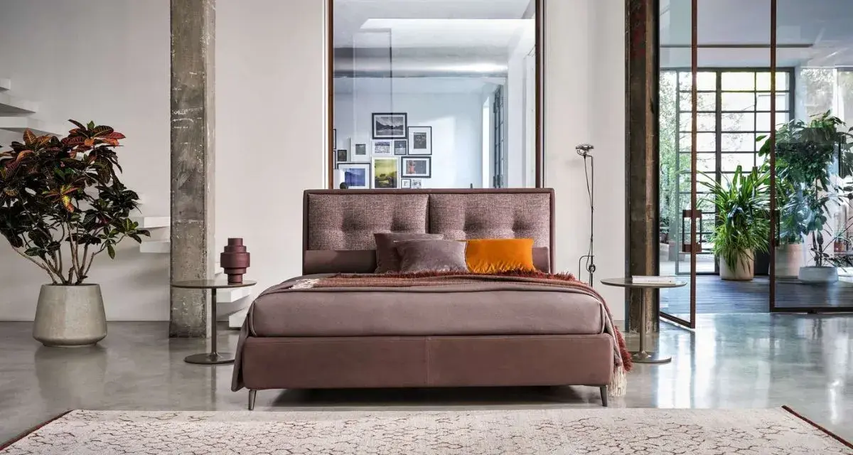Elegante letto con testiera imbottita, parte di una collezione di **marchi camere da letto** di design.