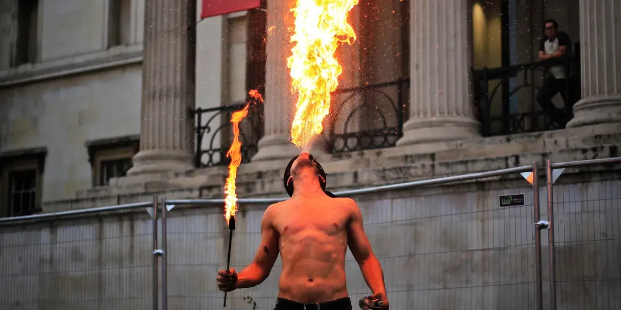 Feuerspucker bläst eine Flamme in die Luft. Man fragt sich, ab wann brennt Rum, wenn man diese Show sieht.