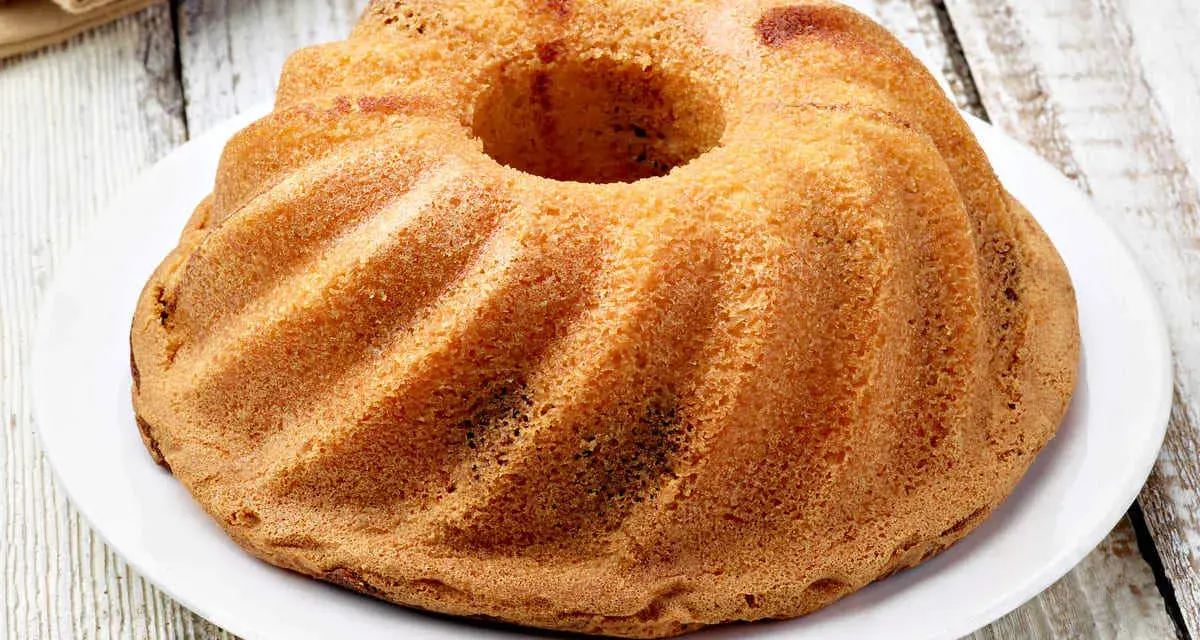 Ciambellone senza uova dorato e soffice, con la sua forma a ciambella, pronto per essere gustato.