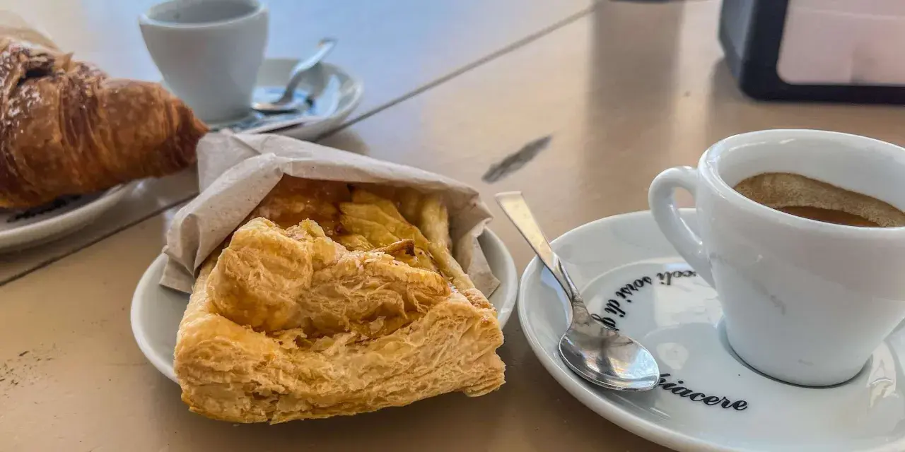 Ein Espresso und ein Croissant – so trinkt man in Italien! Dazu ein süßes Gebäck.