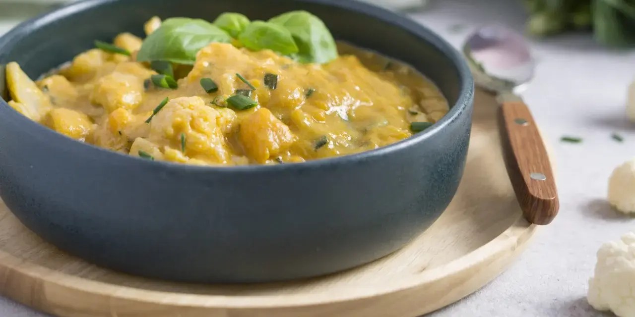 Cremiges Curry mit Blumenkohl, garniert mit Basilikum und Schnittlauch. Ein köstliches Gericht, das Lust auf mehr Blumenkohl Rezepte macht.