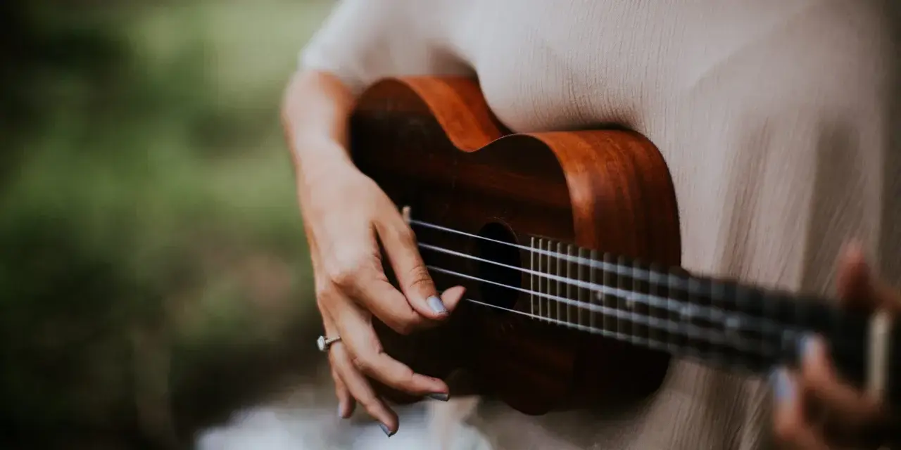 Dłoń grająca na ukulele, które jest często uważane za instrument, na którym najłatwiej nauczyć się grać.