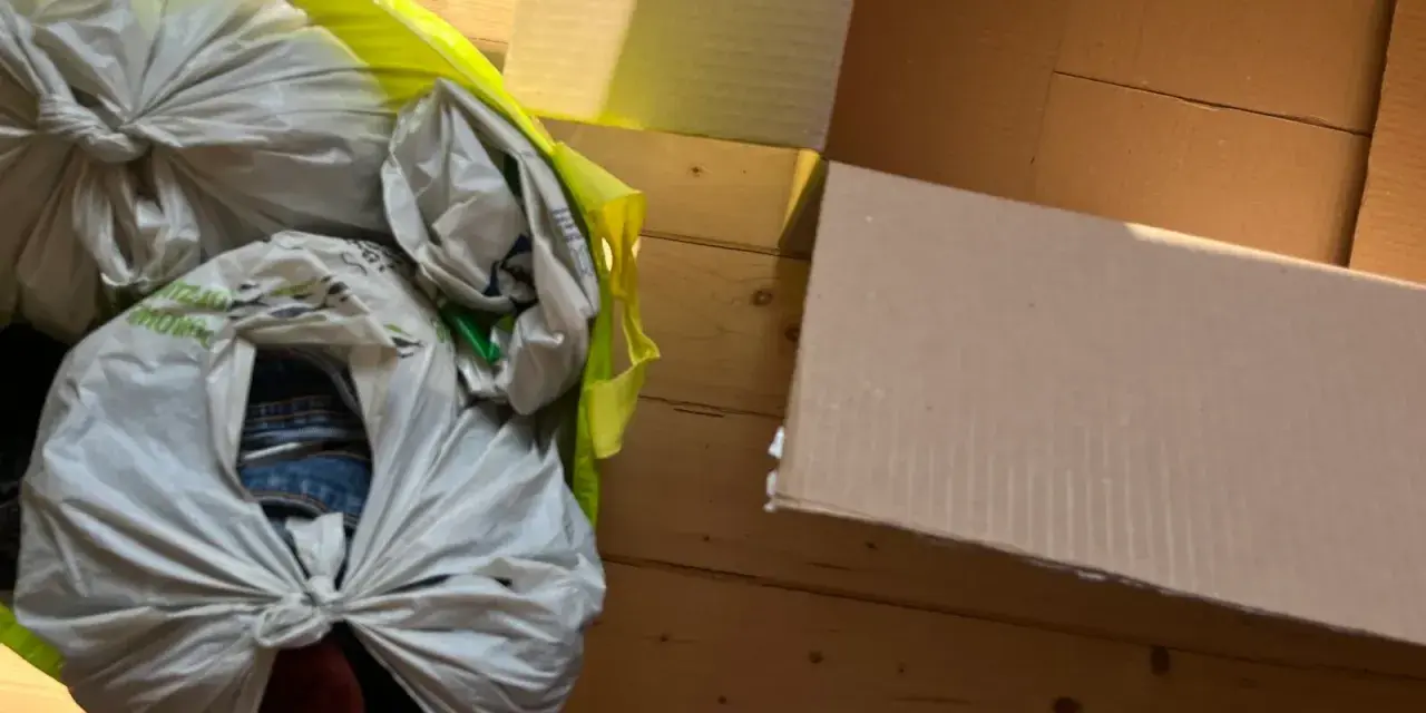 Worek z rzeczami do oddania leży obok otwartego kartonu.