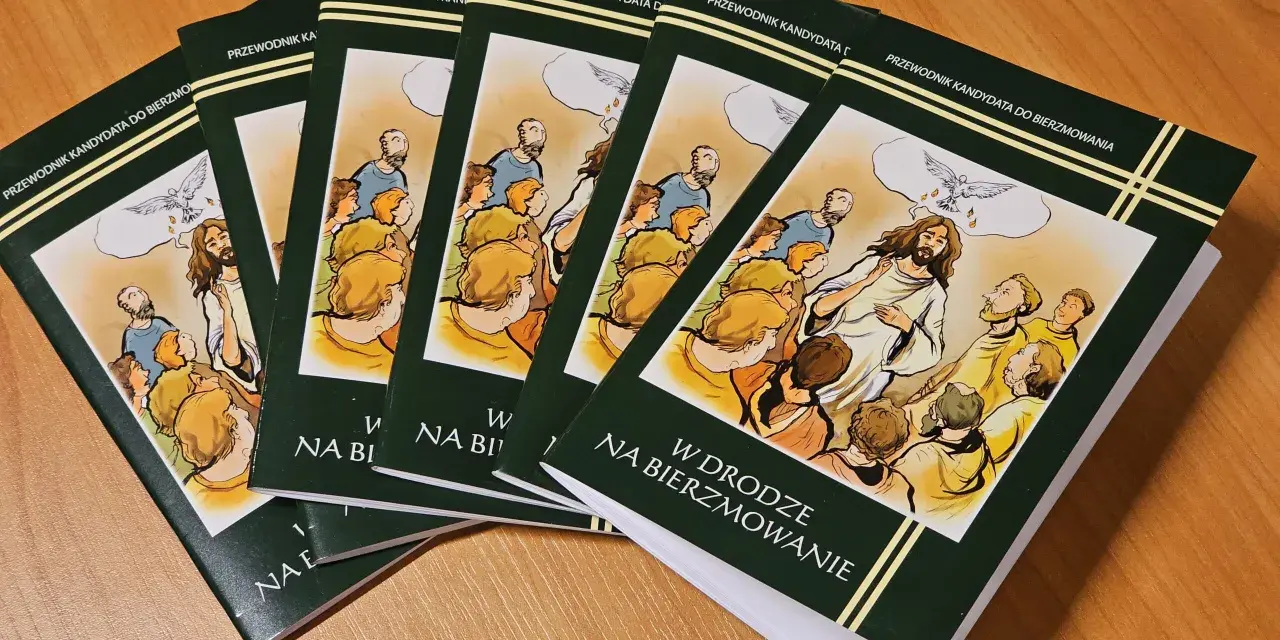 Kilka zielonych książek z ilustracją Jezusa i gołębicy na drewnianym stole.