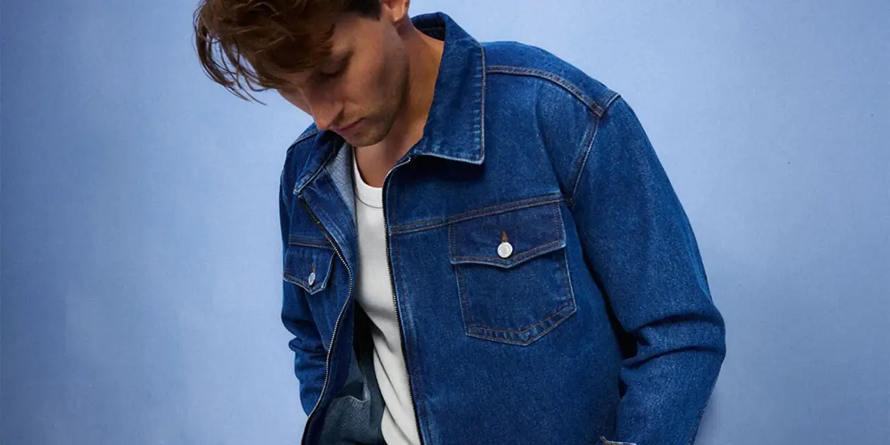 Mężczyzna w dżinsowej kurtce, idealnej do stworzenia uniwersalnej szafy kapsułowej. Klasyczny krój i niebieski denim.