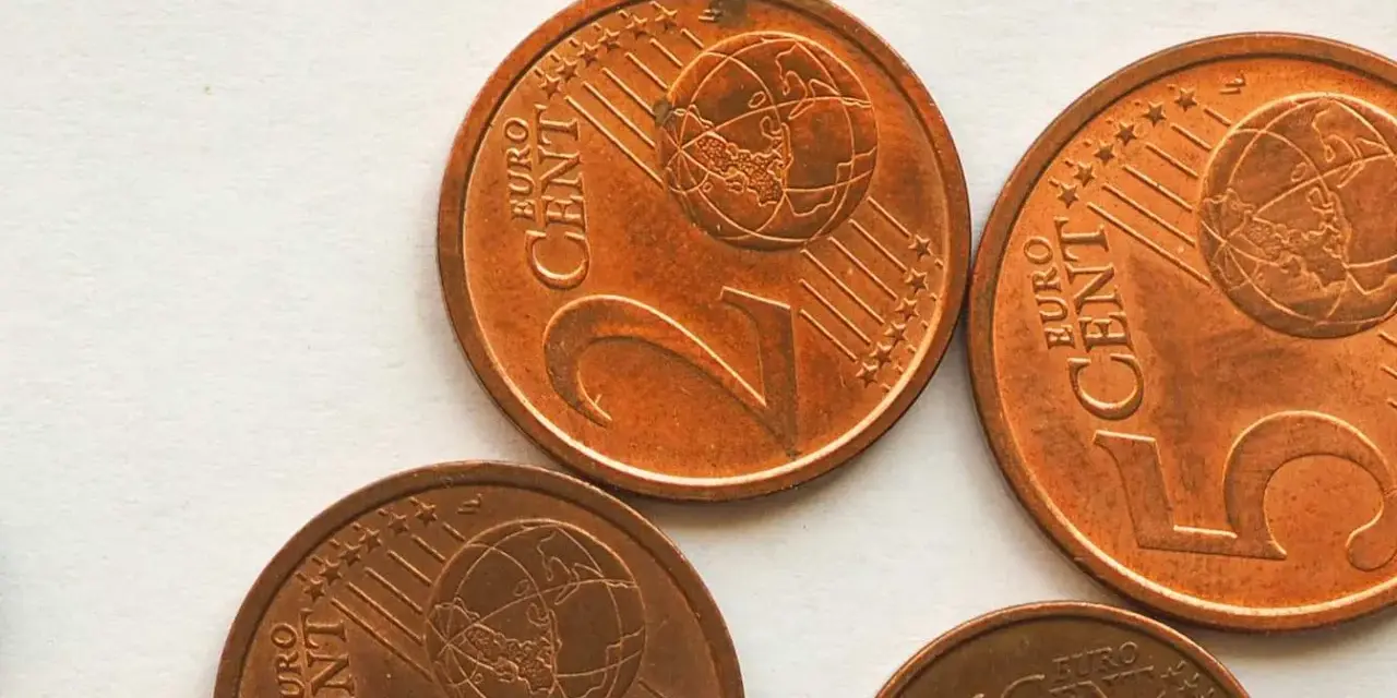 Plusieurs pièces de 2 centimes d'euro, dont une pièce 2 euros rare, sont visibles sur un fond clair.