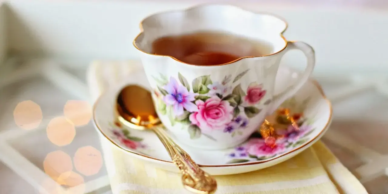 Elegancka filiżanka z kwiatowym wzorem, pełna aromatycznej herbaty. Czy herbata nawadnia? Ta z pewnością tak, dodając chwili relaksu.