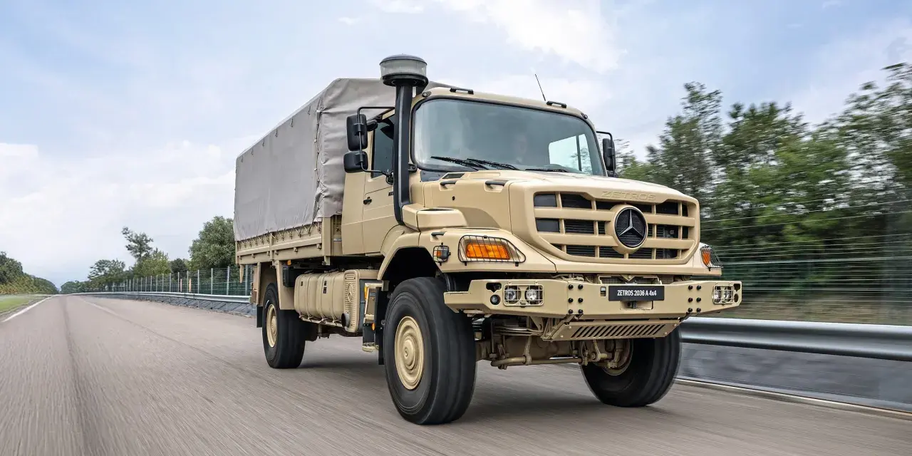 Beżowy Mercedes Zetros 2036 A 4x4 z plandeką jedzie po drodze, gotowy na każde wyzwanie.