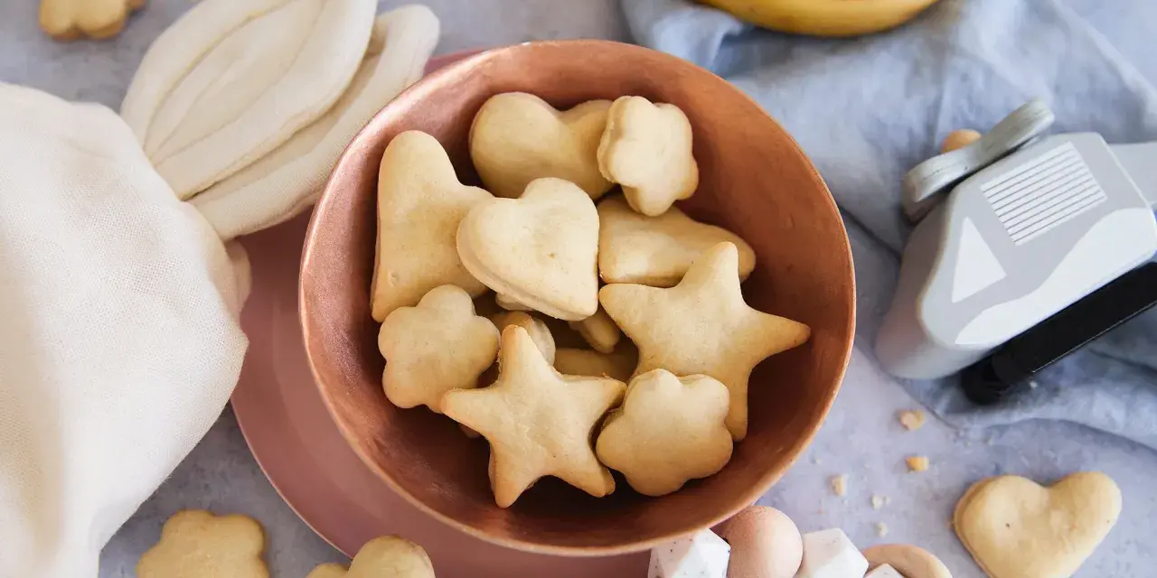 Kleine Sterne und Herzen: Baby Kekse backen ab 6 Monate. Dazu Bananen und ein Holzspielzeug.