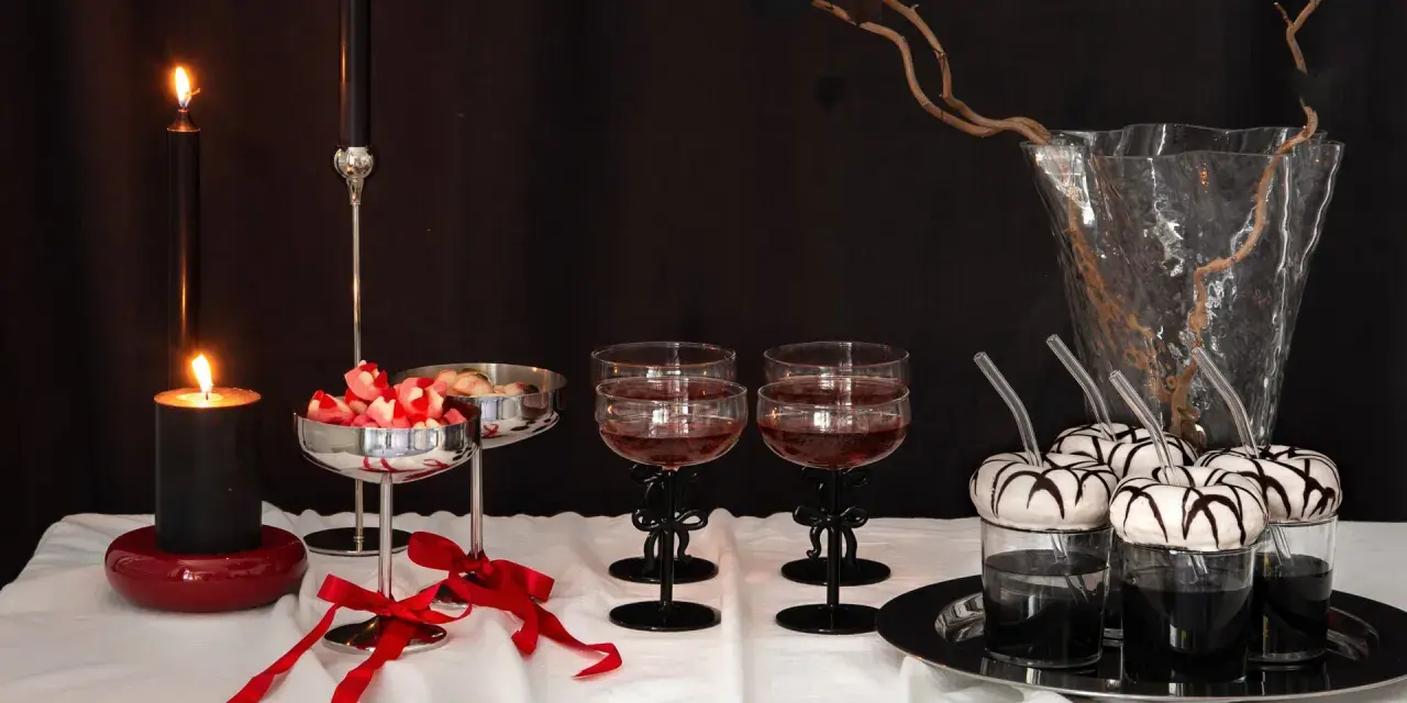 Ett festligt dukat bord med ljus, godis och drinkar. De svarta ljusstakarna med rosetter barn-tema ger en elegant touch.