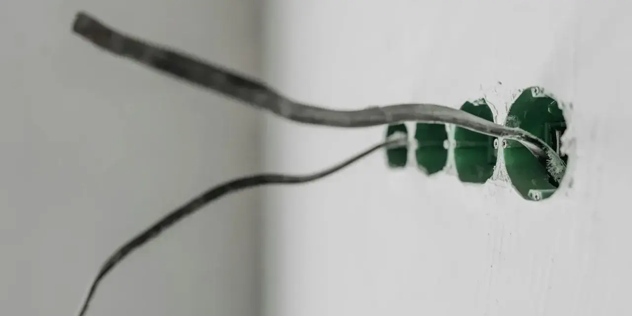 Instalacja elektryczna w ścianie z puszkami pod gniazdka. Uziemienie w gniazdku to klucz do bezpieczeństwa.