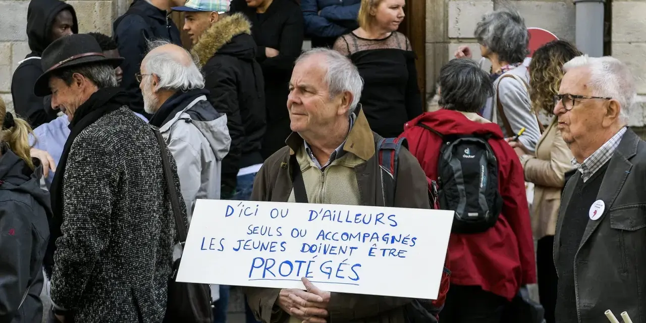 Un homme tient une pancarte "D'ici ou d'ailleurs, seuls ou accompagnés, les jeunes doivent être protégés", soutenant un centre d'accueil pour mineur.
