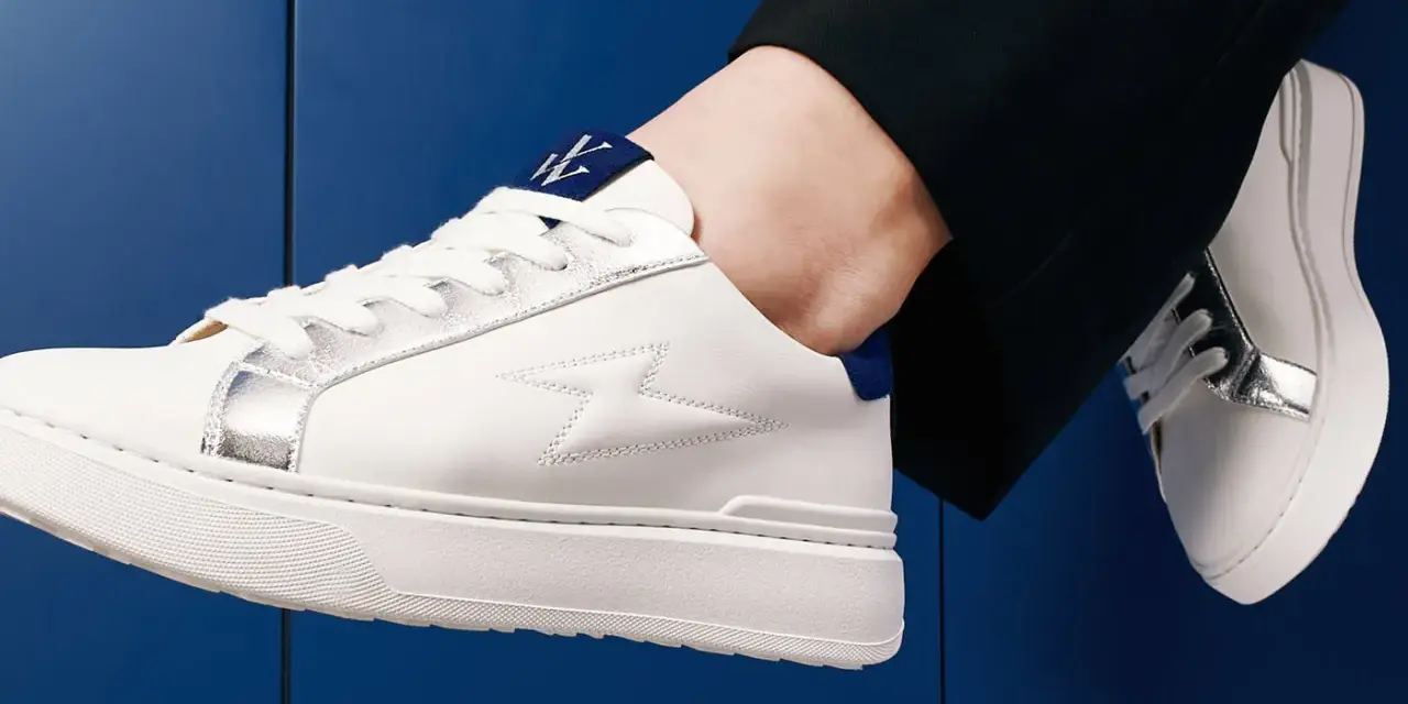 Une tenue chic avec une basket blanche femme, ornée d'éclairs argentés et d'un logo bleu. Parfait pour un look moderne.