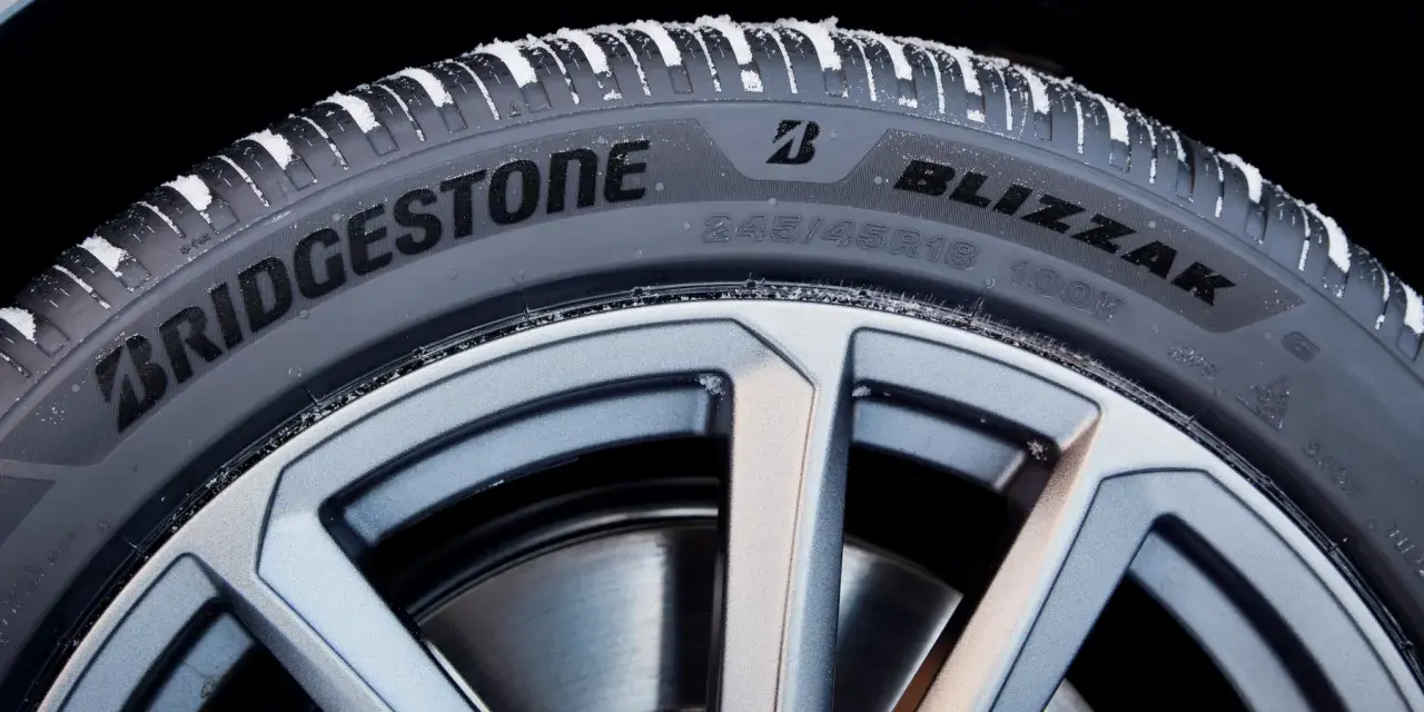 Opony zimowe Bridgestone Blizzak na feldze, pokryte śniegiem. Wiele pozytywnych opony Bridgestone opinie potwierdza ich jakość.