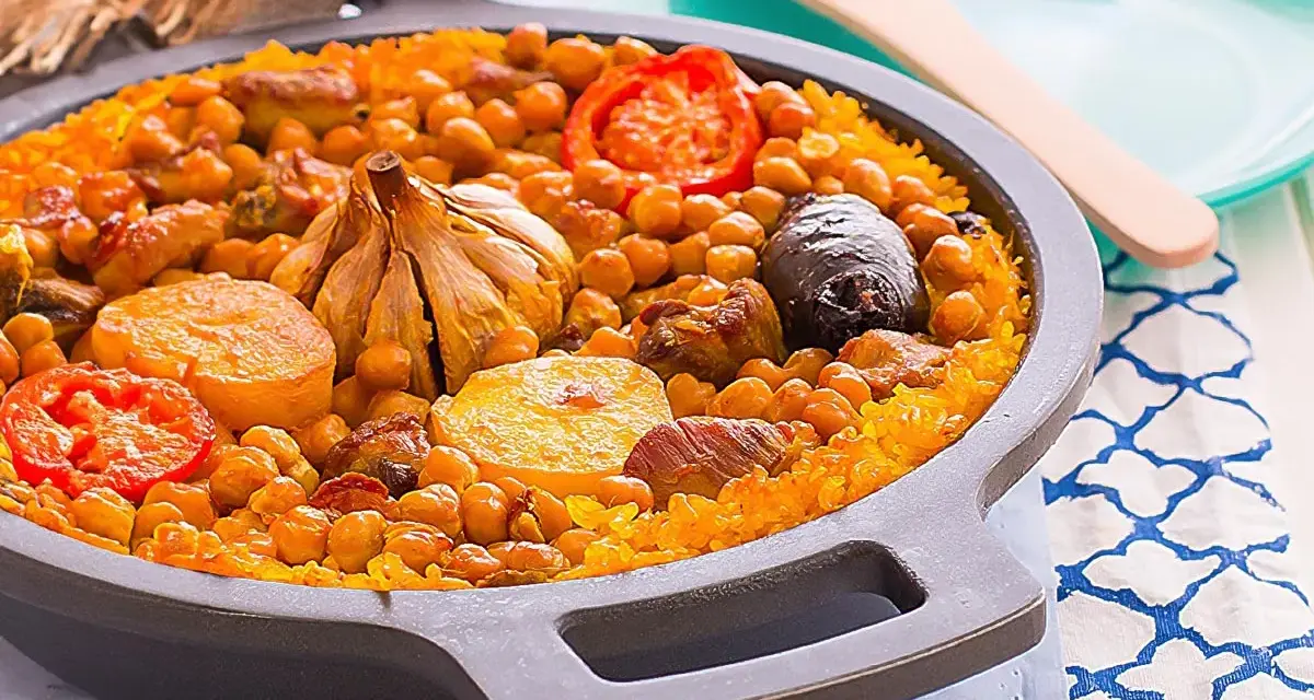 Arroz al horno valenciano con garbanzos, tomate, patata, ajo y morcilla en una paellera.