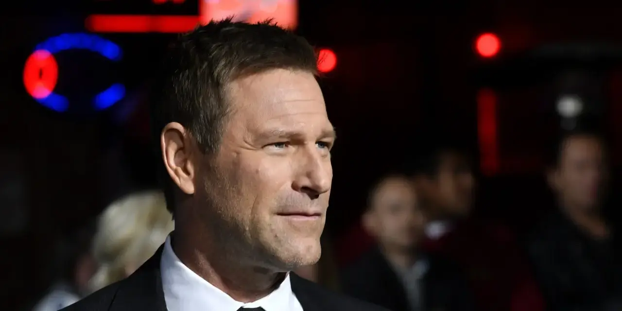 Aaron Eckhart, protagonista di molti film, in primo piano con uno sguardo intenso.