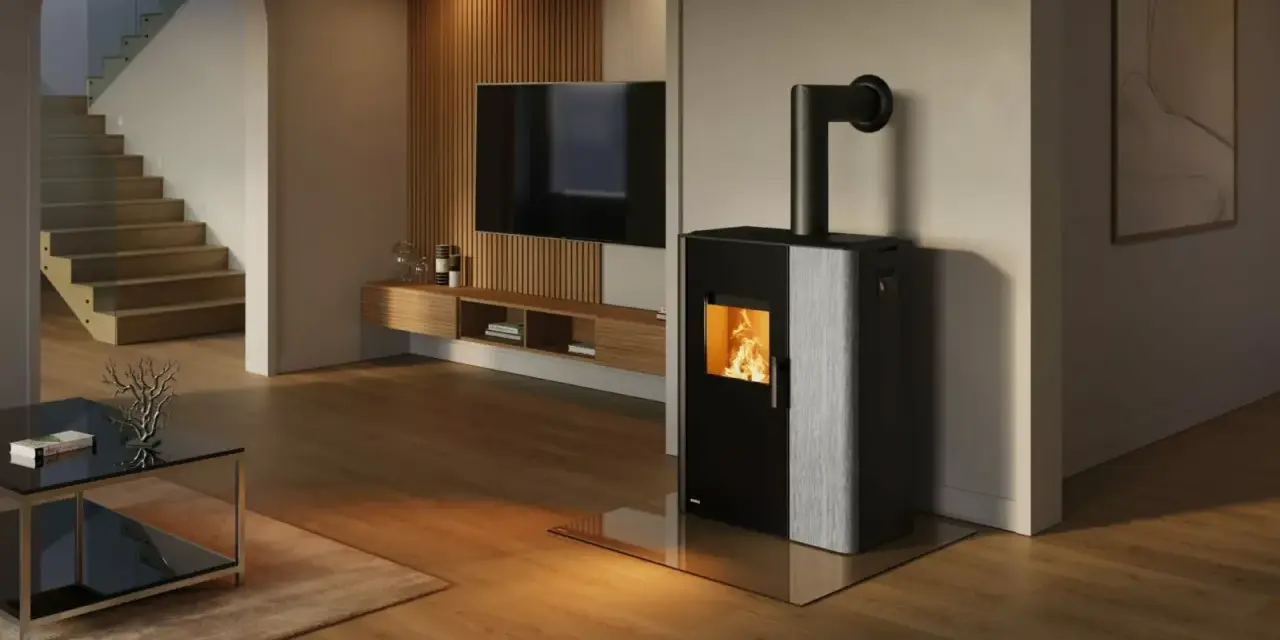 Estufa mixta pellets y leña canalizable, con fuego encendido, en un salón moderno con escaleras y TV.