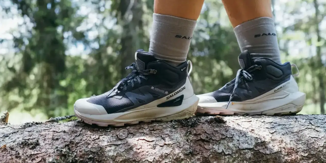 Buty trekkingowe Salomon na pniu drzewa w lesie. Salomon to firma znana z wysokiej jakości obuwia outdoorowego.
